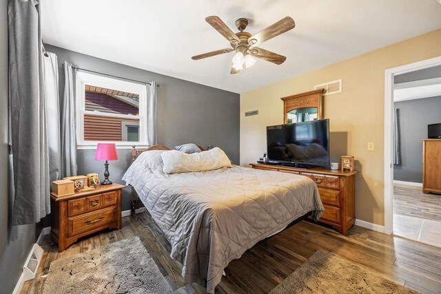 bedroom featuring light wood-type flooring, baseboards, visible vents, and ceiling fan