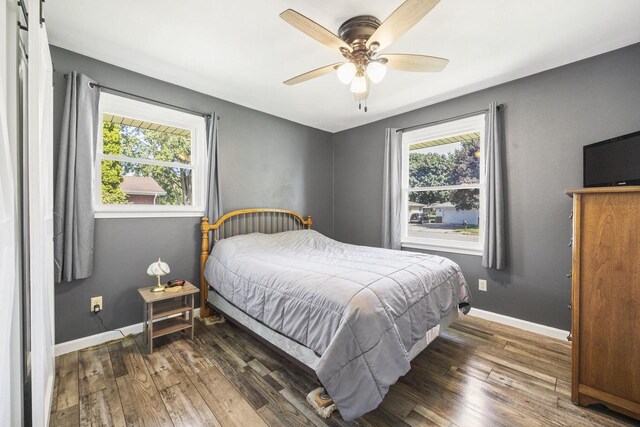 bedroom with ceiling fan, baseboards, and wood finished floors