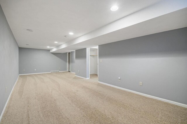 finished below grade area with recessed lighting, baseboards, visible vents, and light colored carpet