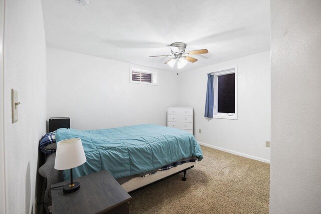 carpeted bedroom with ceiling fan and baseboards