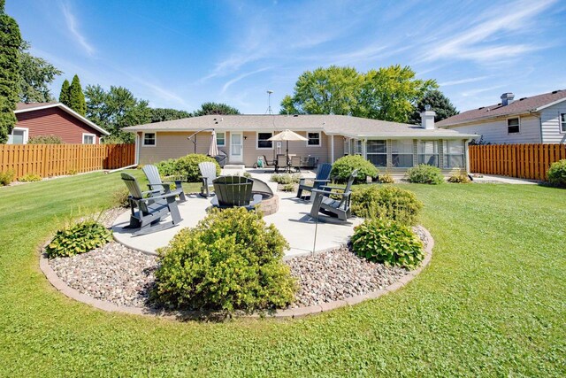 rear view of property featuring a patio, fence, and a lawn