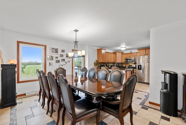 tiled dining room featuring an inviting chandelier