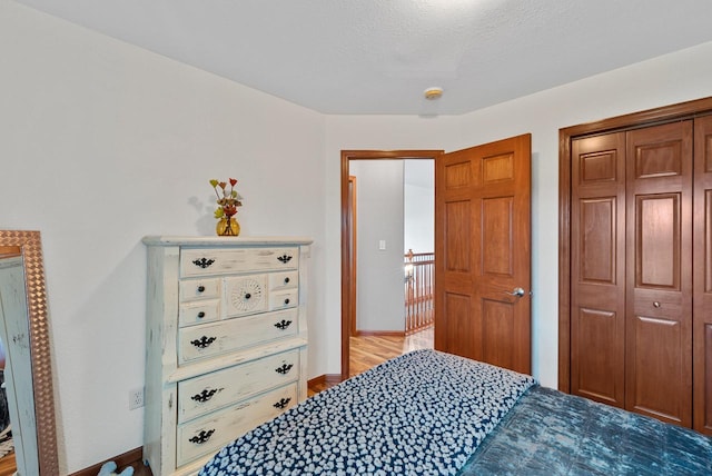 bedroom featuring hardwood / wood-style flooring and a textured ceiling