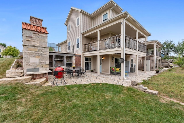 rear view of house with a lawn, a patio, a balcony, and central air condition unit