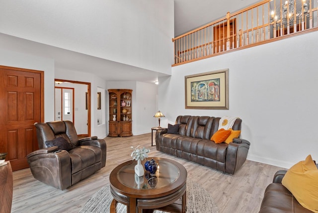 living room with a high ceiling and light hardwood / wood-style flooring