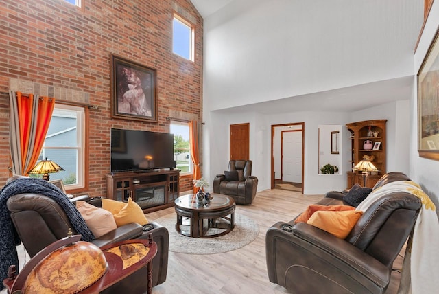 living room with a wealth of natural light, light hardwood / wood-style flooring, and high vaulted ceiling