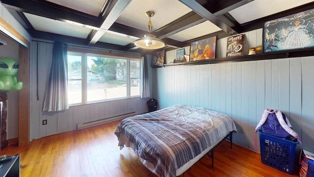 bedroom with coffered ceiling, wooden walls, hardwood / wood-style flooring, a baseboard radiator, and beamed ceiling