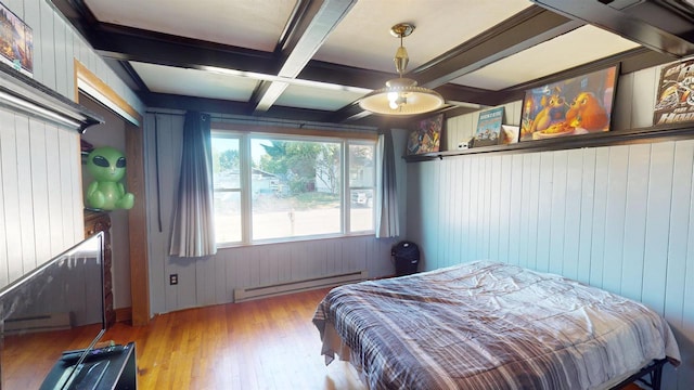 bedroom with coffered ceiling, baseboard heating, wooden walls, beam ceiling, and light hardwood / wood-style floors