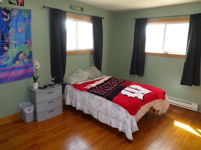 bedroom featuring hardwood / wood-style flooring and baseboard heating