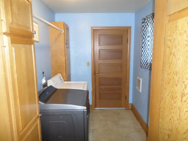 washroom with cabinets, washing machine and dryer, and light colored carpet