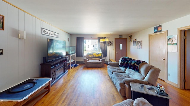 living room featuring wooden walls and light hardwood / wood-style flooring