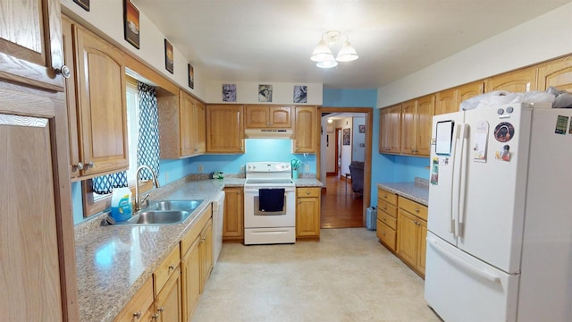 kitchen featuring light stone countertops, white appliances, and sink