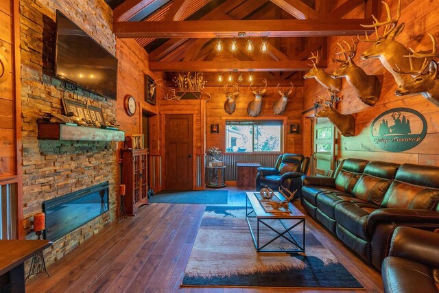 living room with high vaulted ceiling, wood-type flooring, a fireplace, and beamed ceiling