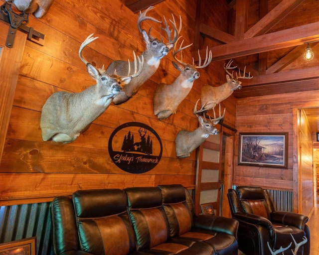 home theater featuring wooden walls and beamed ceiling