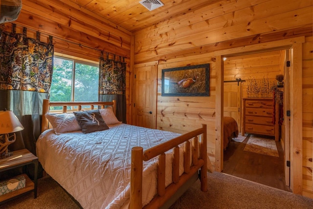 bedroom with wood-type flooring, wooden walls, and wooden ceiling