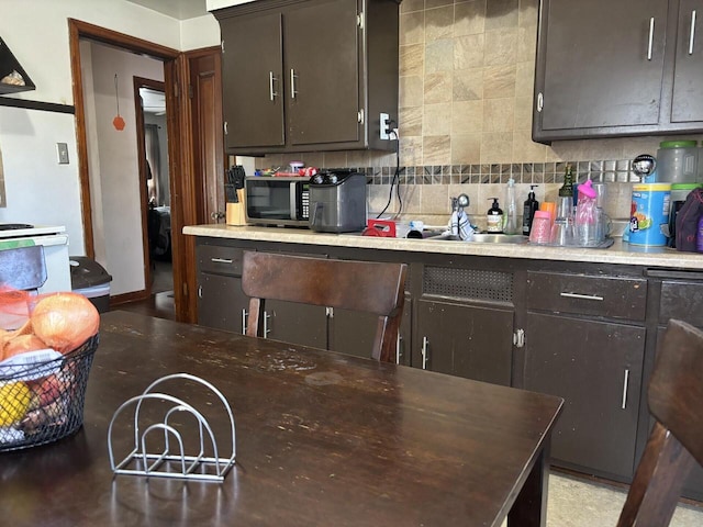 kitchen with dark brown cabinets, sink, and decorative backsplash