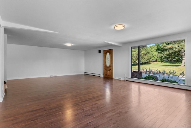 empty room with baseboards, a baseboard heating unit, and dark wood-style flooring