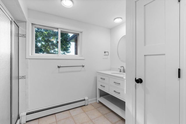 full bathroom featuring a baseboard radiator, vanity, baseboards, tile patterned floors, and a stall shower