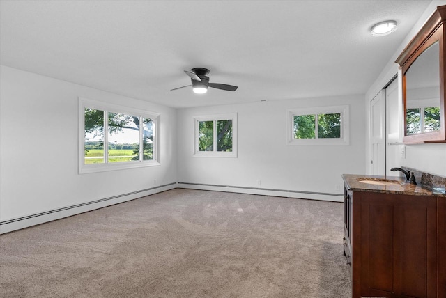 spare room featuring carpet flooring, a sink, and ceiling fan