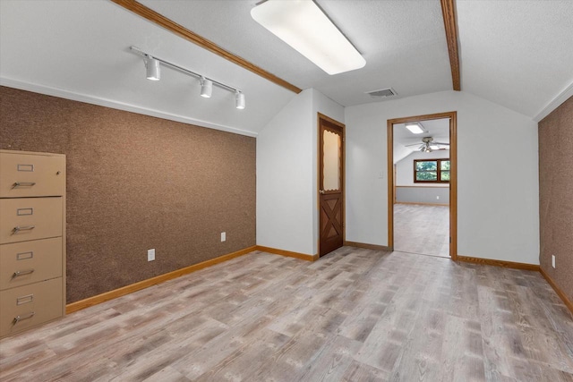 unfurnished room with lofted ceiling, visible vents, light wood-style flooring, and baseboards