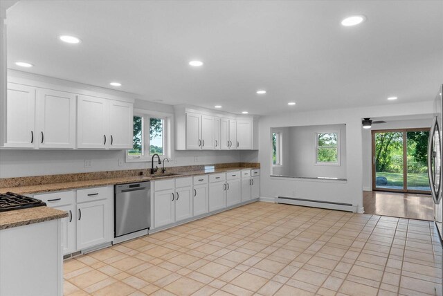 kitchen featuring dishwasher, plenty of natural light, a baseboard radiator, and white cabinets