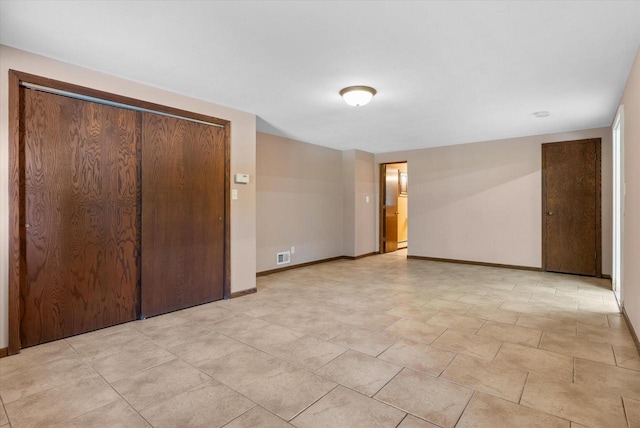 unfurnished bedroom with baseboards, visible vents, and a closet