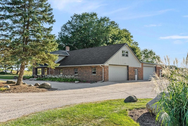 view of front of house with a garage, a shingled roof, a chimney, aphalt driveway, and brick siding