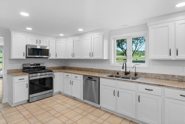 kitchen with stainless steel appliances, recessed lighting, white cabinets, and a sink