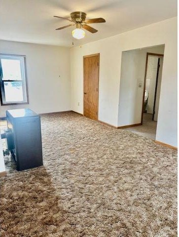 carpeted spare room with ceiling fan