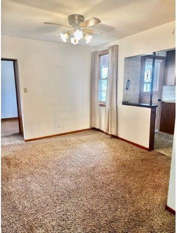 unfurnished room with ceiling fan and carpet floors