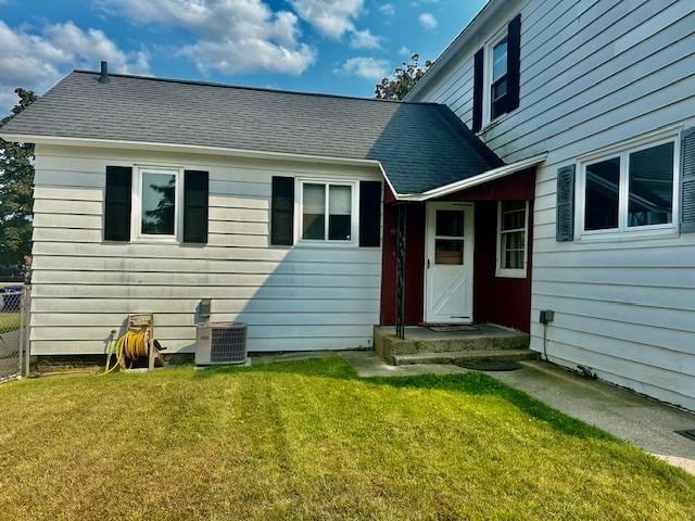 rear view of house with a lawn and central AC