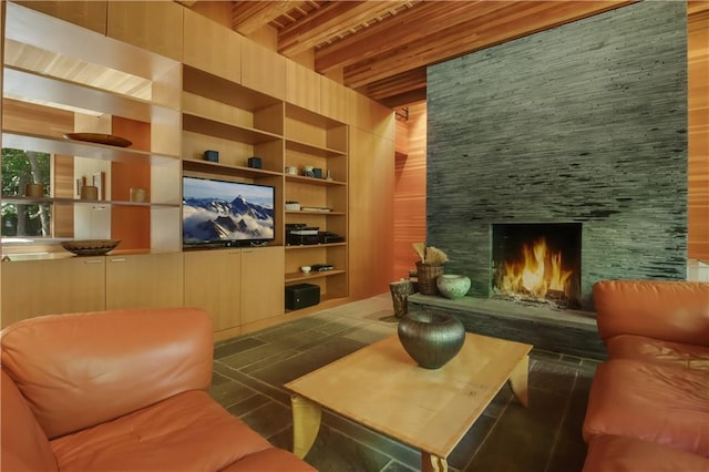 interior space featuring beamed ceiling and a large fireplace