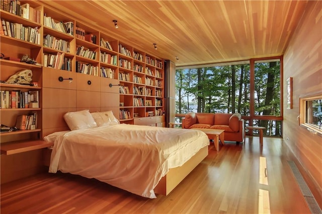 bedroom with wood ceiling, wood finished floors, and floor to ceiling windows