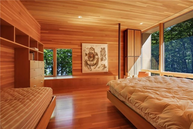 unfurnished bedroom with wooden ceiling, wooden walls, and wood finished floors