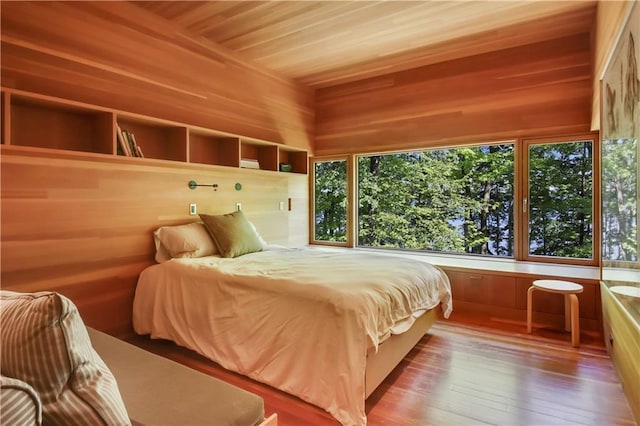 bedroom featuring hardwood / wood-style flooring, wood ceiling, and wood walls