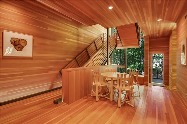 dining space with recessed lighting, wood walls, wood ceiling, and hardwood / wood-style flooring