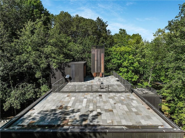 wooden deck with a storage shed, an outbuilding, and a patio