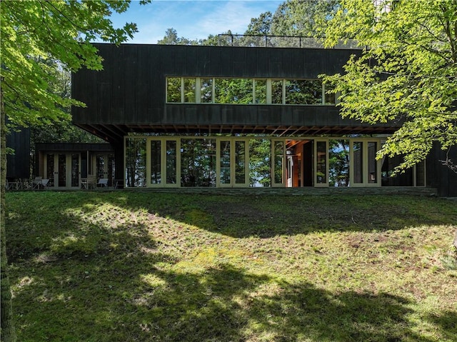 back of property with a yard and french doors