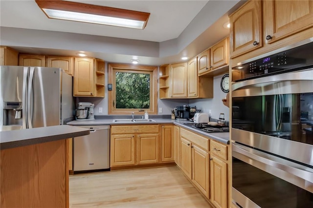 kitchen featuring appliances with stainless steel finishes, light hardwood / wood-style floors, and sink