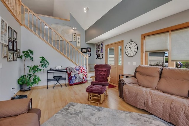 living room featuring high vaulted ceiling and light hardwood / wood-style floors