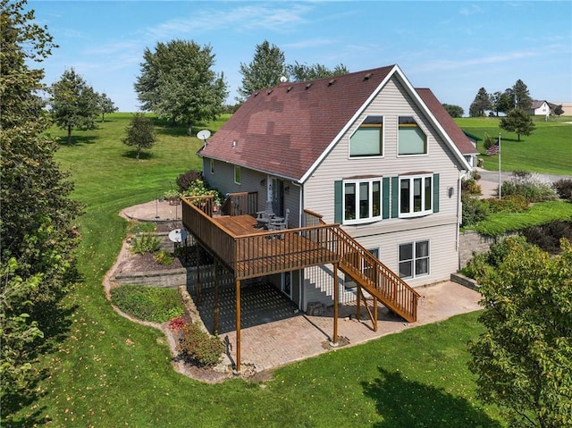 back of house with a yard, a wooden deck, and a patio