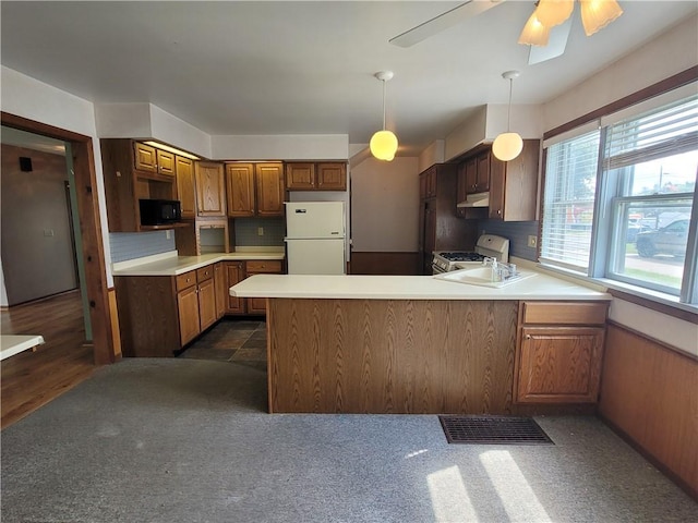 kitchen featuring white appliances, kitchen peninsula, sink, and ceiling fan