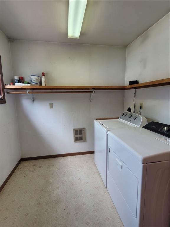 laundry area with heating unit and washer and clothes dryer