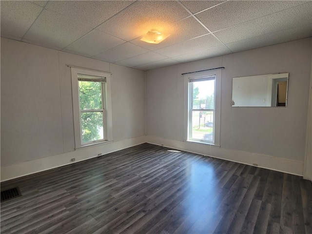 empty room with dark wood-type flooring and a paneled ceiling