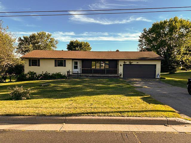 ranch-style house with aphalt driveway, an attached garage, and a front lawn