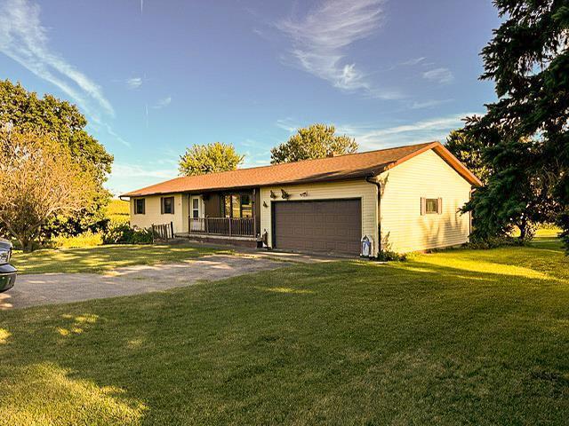 ranch-style home featuring a front lawn, an attached garage, and driveway