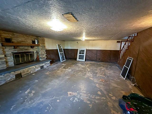 finished basement featuring stairs and a fireplace