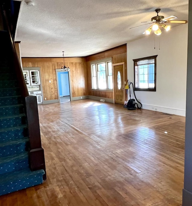 unfurnished living room with a textured ceiling, wood-type flooring, and ceiling fan