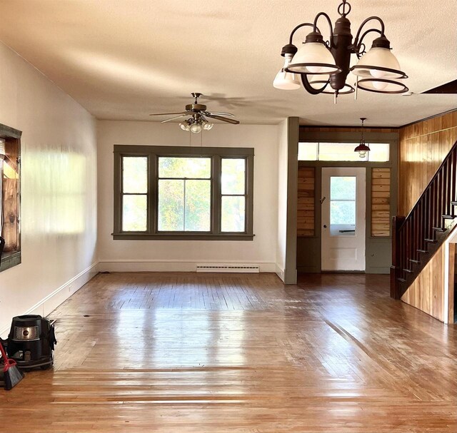 110 N Main St, Greenwood, WI 54437 - unfurnished living room featuring stairway, baseboards, ceiling fan with notable chandelier, and wood finished floors