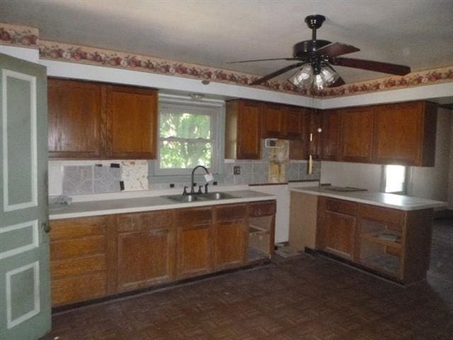 kitchen featuring dark parquet flooring, ceiling fan, backsplash, and sink